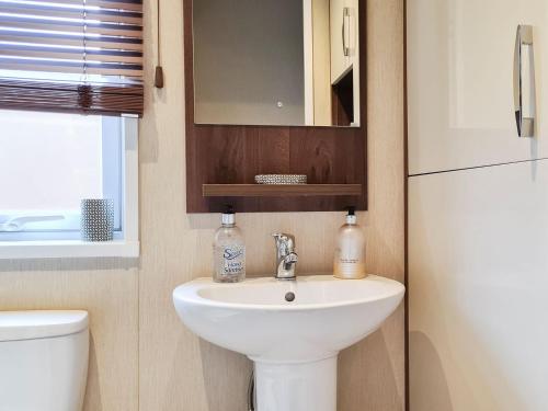 a bathroom with a sink and a toilet and a mirror at Glen Clova in Forfar