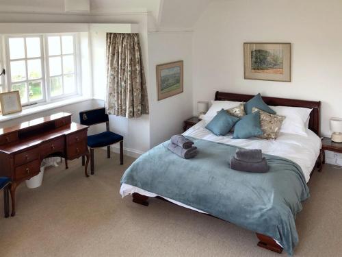 a bedroom with a large bed with a desk and a bed sidx sidx sidx at Castle Hill House in Sidbury