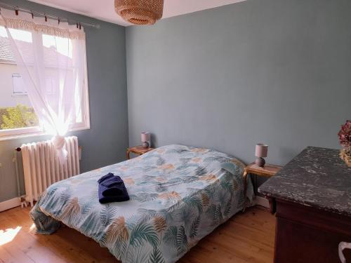 a small bedroom with a bed and a window at La maison aux volets bleus in Le Vigean