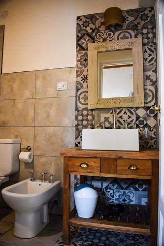 Un baño con lavabo, inodoro y espejo. en Cabañas La Sorpresa, en Tilcara
