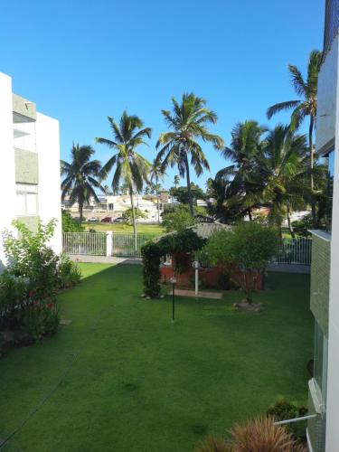 uma vista para um quintal com palmeiras em Jardim Tropical em Lauro de Freitas