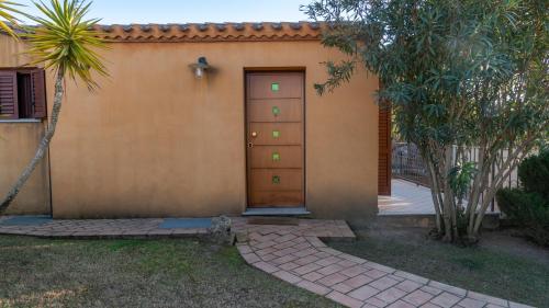 a door to a house with a driveway at Welcomely - Sa Perda in Tortolì