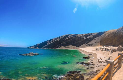 vistas a una playa con gente en el agua en Hotel Ocean Beach Paracas en Paracas