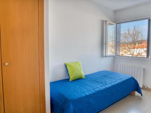 ein Schlafzimmer mit einem blauen Bett und einem Fenster in der Unterkunft Piso les Pites in Palamós