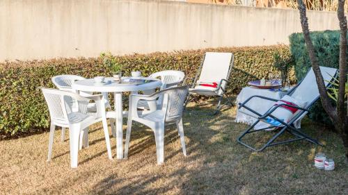 a white table and chairs in a yard at Welcomely - Sa Perda in Tortolì