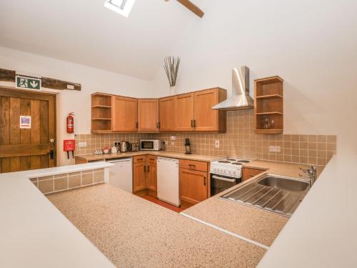 a kitchen with wooden cabinets and a sink at Honeysuckle Cottage in Worcester