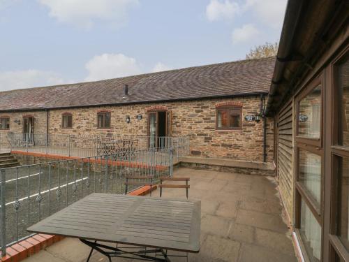 a patio with a table and a building at Honeysuckle Cottage in Worcester