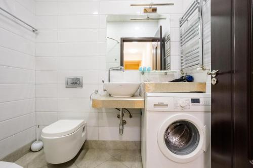 a bathroom with a sink and a washing machine at Rustaveli Three Bedroom Apartment with Amazing views in Tbilisi City