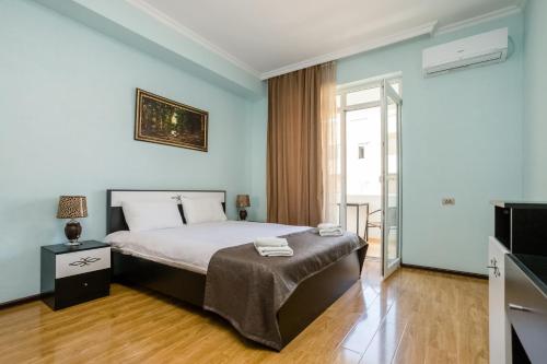 a bedroom with a bed and a television in it at Rustaveli Three Bedroom Apartment with Amazing views in Tbilisi City