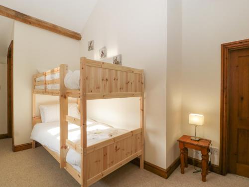 a bedroom with two bunk beds in a room at Larch Bed Cottage in Worcester