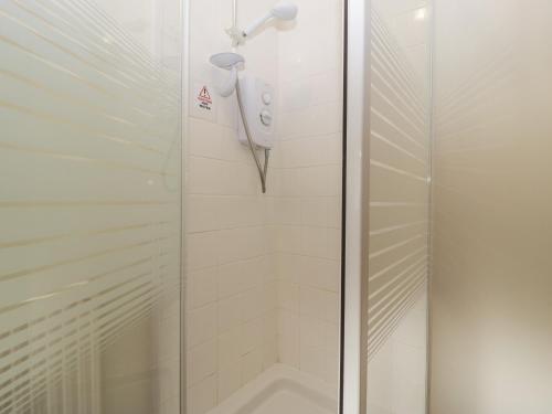 a shower in a bathroom with a glass door at Larch Bed Cottage in Worcester