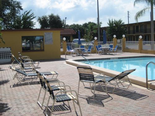 a group of chairs and tables and a swimming pool at Gulf Way Inn Clearwater in Clearwater