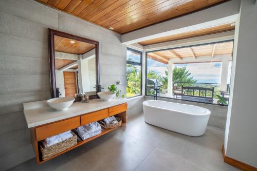 baño con 2 lavabos y espejo grande en Flower’s Paradise Monteverde, en Monteverde
