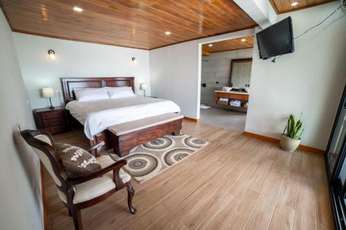 a bedroom with a bed and a flat screen tv at Flower’s Paradise Monteverde in Monteverde Costa Rica