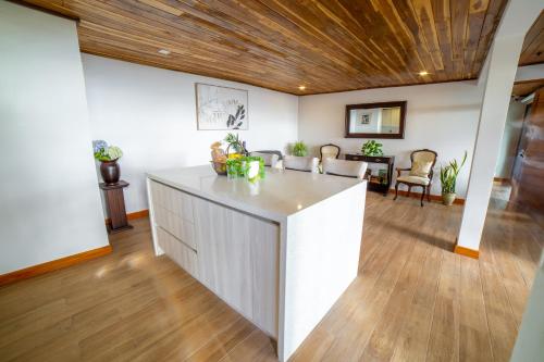 a kitchen and living room with a wooden ceiling at Flower’s Paradise Monteverde in Monteverde Costa Rica