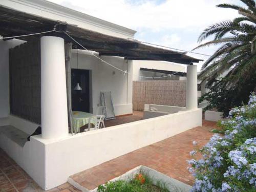 a white house with a patio with a table at Ca Balena piccola e grande in Stromboli