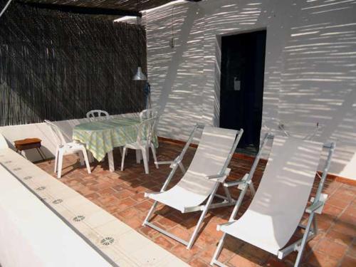 a patio with a table and chairs on a brick floor at Ca Balena piccola e grande in Stromboli