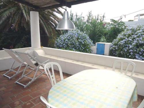 a patio with a table and chairs and a pendant light at Ca Balena piccola e grande in Stromboli