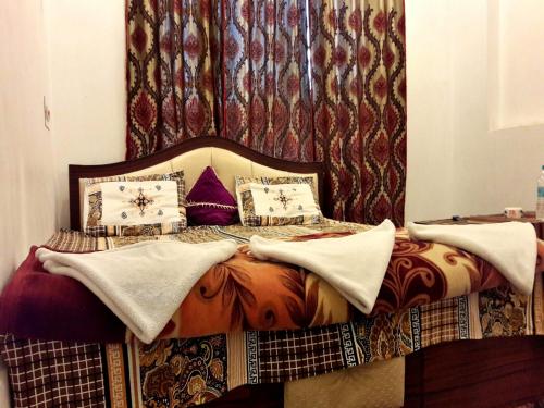 a bed with pillows on it in a bedroom at Hotel Fabulous Kashmir in Srinagar