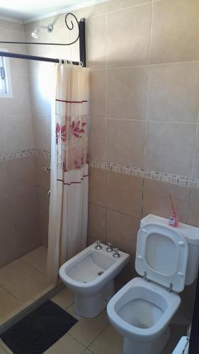 a bathroom with a toilet and a shower and a bidet at Alquileres Pedro in Olavarría