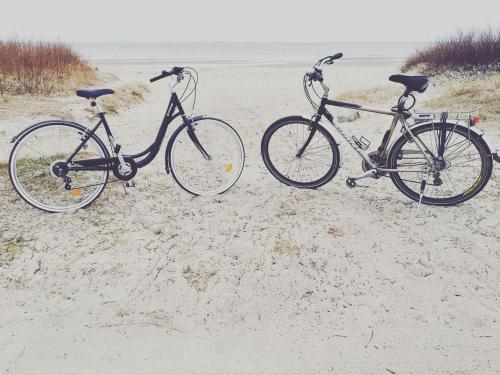 zwei Fahrräder im Sand am Strand geparkt in der Unterkunft Dom Kawalera in Kadyny