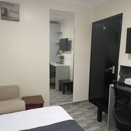 a bedroom with a bed and a living room at Sharz place in Nairobi