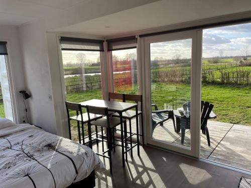 - une chambre avec un lit et un balcon avec une table et des chaises dans l'établissement Containerwoning op schitterende locatie, à Milsbeek