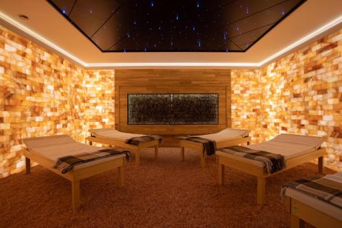 a room with four beds and a wall of bricks at ARDEN PALACE Medical Resort & SPA in Satanov