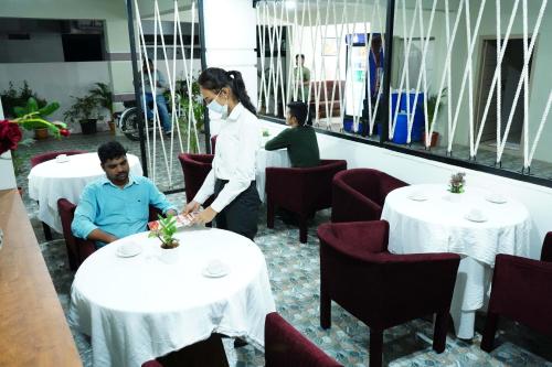 Una donna in piedi sopra due tavoli in un ristorante di The Central Suites Vizag a Visakhapatnam