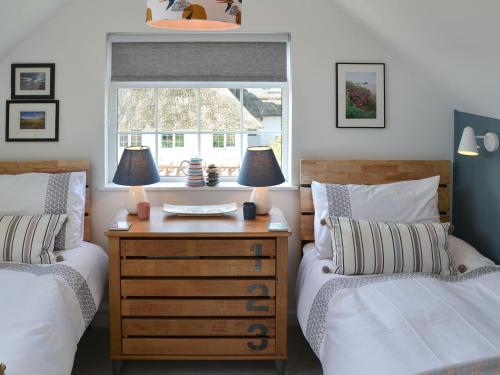 a bedroom with two beds and a desk with two lamps at Beach Haven in Sheringham