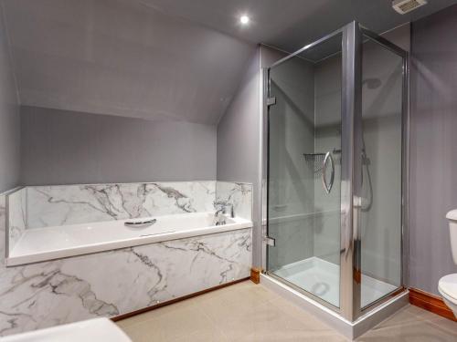 a bathroom with a shower and a bath tub at The Old Boathouse in Cromdale