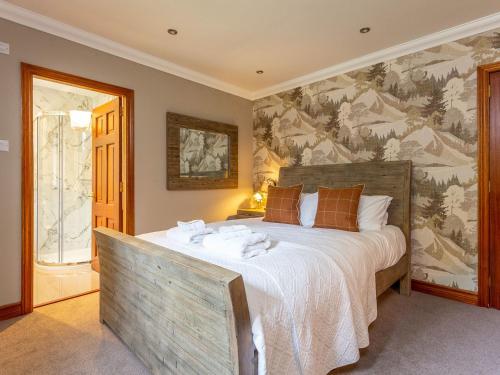 a bedroom with a large bed with a painting on the wall at The Old Boathouse in Cromdale