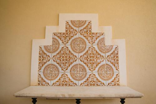 a wall with a cross on top of a bench at Casale la Macina Residence Scopello in Scopello