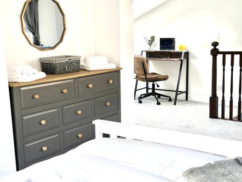 a bedroom with a dresser with a mirror and a desk at Cosy One Bedroom Apartment in Trowbridge