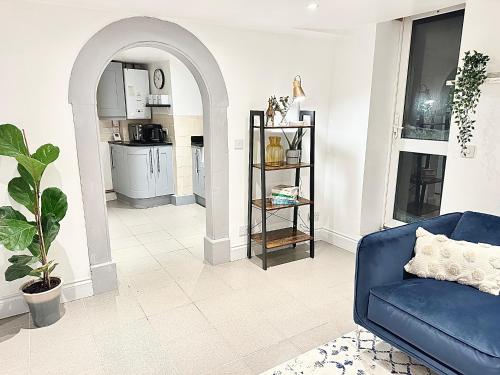 uma sala de estar com um sofá azul e uma cozinha em Cosy One Bedroom Apartment em Trowbridge