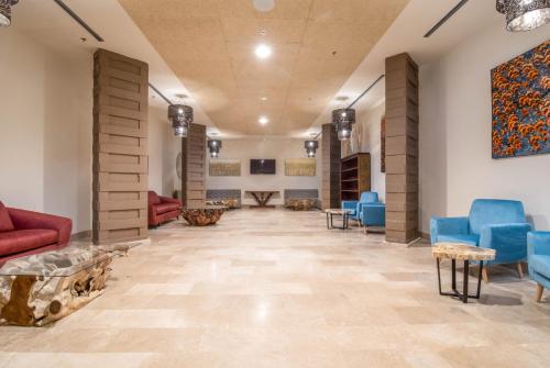 a lobby of a hospital with blue chairs and tables at Cádiz Bahía by QHotels in Cádiz