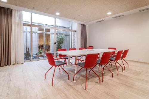 a conference room with a white table and red chairs at Cádiz Bahía by QHotels in Cádiz