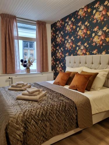 1 dormitorio con 1 cama grande y papel pintado con motivos florales en bijDorien, en Gennep