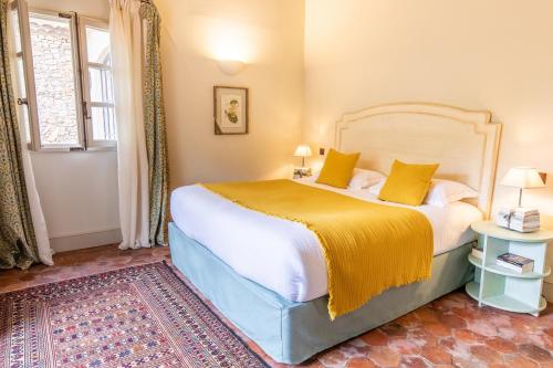 a bedroom with a large bed with a yellow blanket at Château de Berne in Lorgues