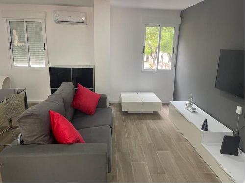a living room with a gray couch and red pillows at Moderno apartamento en Elche in Elche