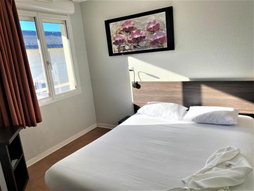 1 dormitorio con cama blanca y ventana en ApartHotel Sainte-Marthe en Aviñón