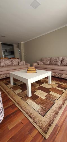 a white coffee table in a living room with a couch at Departamento Caseros in Salta