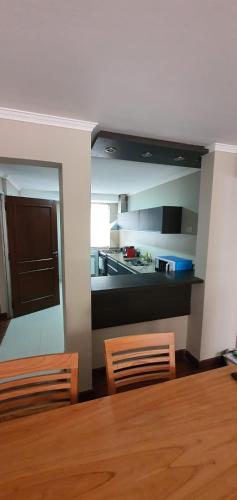 a kitchen with a table and two chairs and a table and a kitchen at Departamento Caseros in Salta
