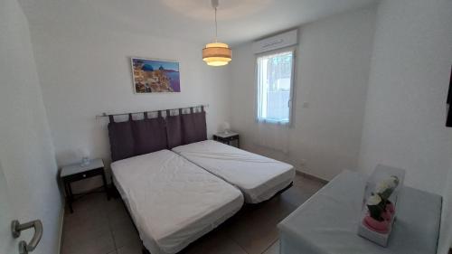 niewielka sypialnia z łóżkiem i stołem w obiekcie LES SILENES - Maison 3 chambres proche plage w mieście Saint-Jean-de-Monts