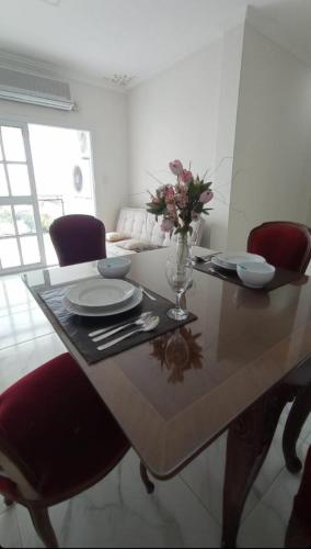 una mesa de comedor con un jarrón de flores. en EDIFICIO PARIS DPTO 84 en Resistencia