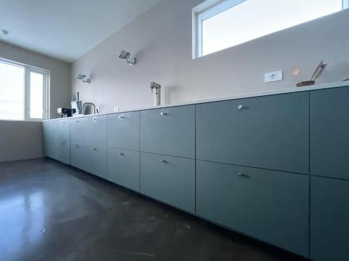 a large kitchen with white cabinets and a window at Óspaksstaðir- New Renovated Farm in Hrútafjörður in Staður