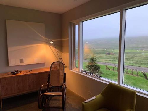 a room with a desk and a chair and a large window at Óspaksstaðir- New Renovated Farm in Hrútafjörður in Staður