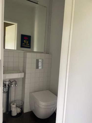 a bathroom with a toilet and a clock on the wall at Óspaksstaðir- New Renovated Farm in Hrútafjörður in Staður
