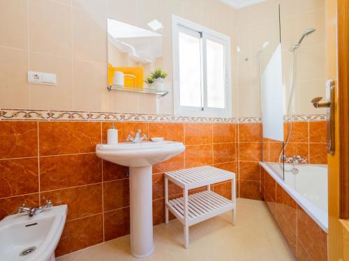 een badkamer met een wastafel, een toilet en een bad bij Cubo's Liberty Apartment in Alhaurín el Grande