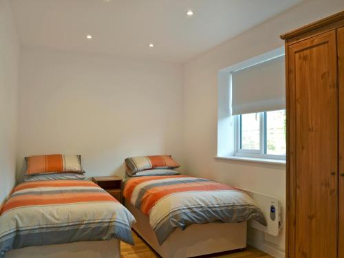 2 Betten in einem Zimmer mit Fenster in der Unterkunft Tawny Owls in Godstone